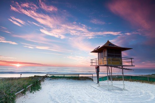 lifeguard hut on australian beach at sunrise with interesting clouds in background (gold coast, queensland, australia)