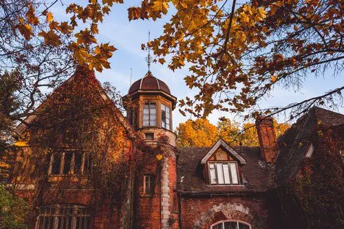 Manor house with trees in autumn colors and fall trees