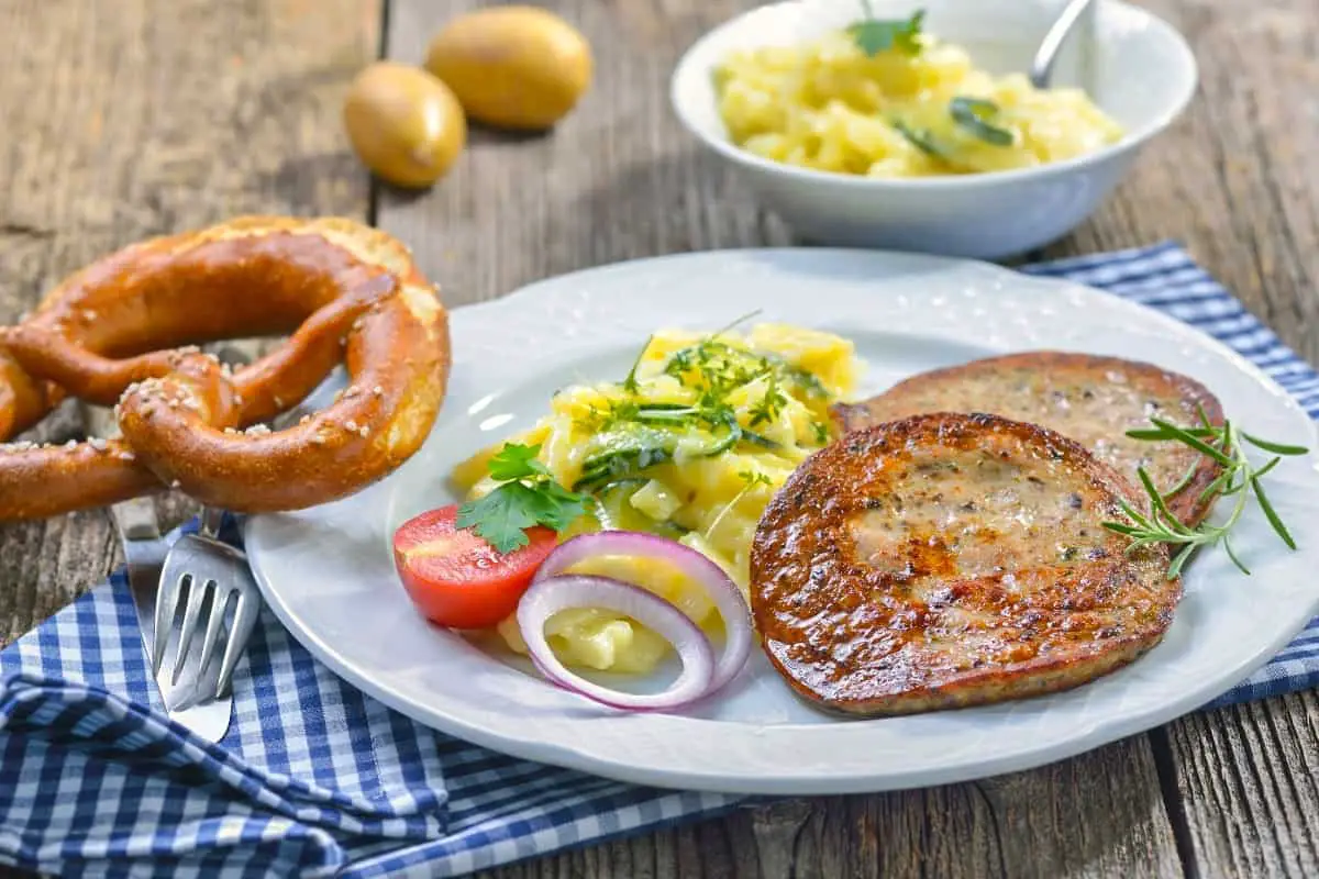 Fried slices of sausage with Milzwurst served with potato salad and a fresh German pretzel